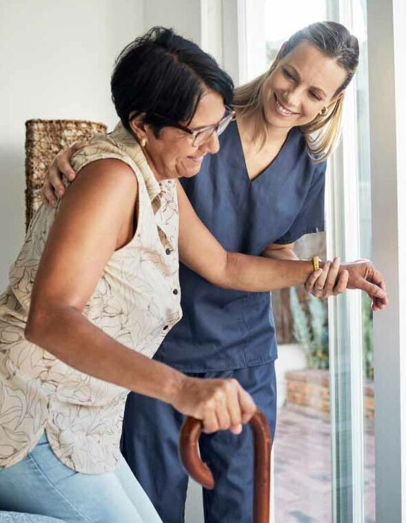 Pflegerin hilft älterer Person aufzustehen